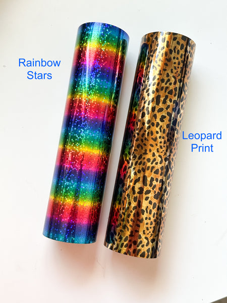 a roll of rainbow stars next to a roll of leopard print